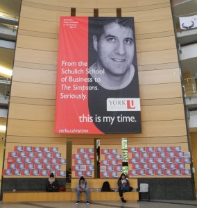 The University's $6million "this is my time" promotion campaign is here contrasted with the 2014 York Federation of Students' 2014 "#thisismydebt" effort to protest tuition fee increases. The small poster displace list the student debts of individual students. University staff quickly removed them.